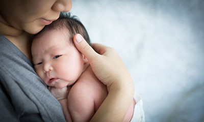 Mother holding baby boy to chest