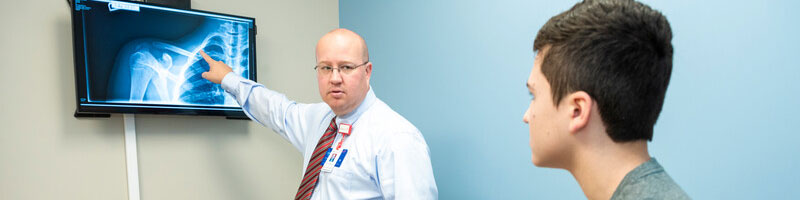 Physician showing scans to teenage boy