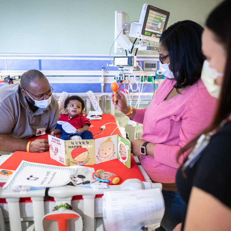 family reading book to baby