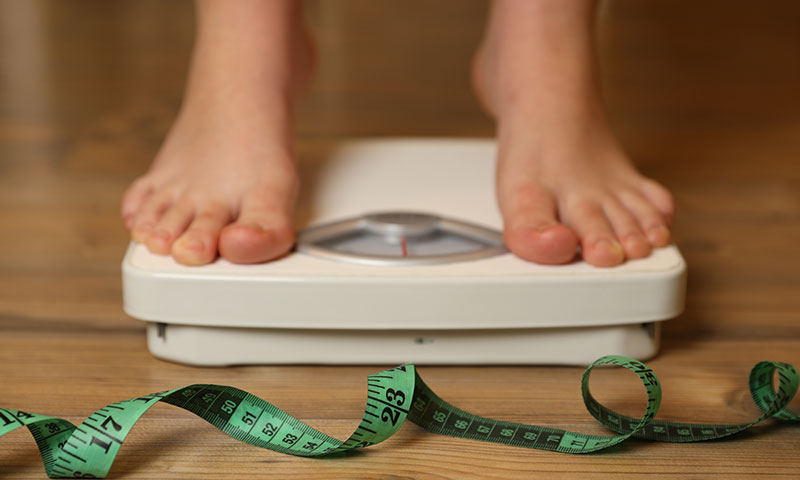 Someone standing on a weight scale.