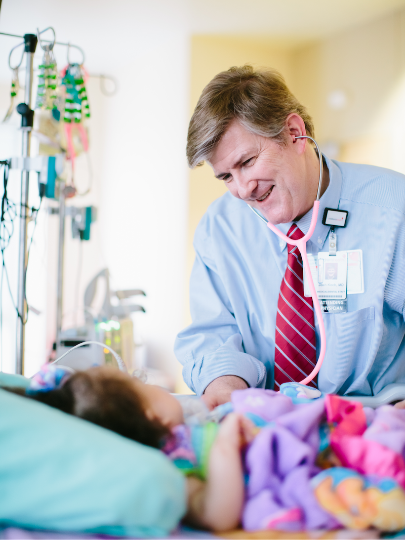 Cardiologist monitoring a pediatric patient's heart with a stethoscope