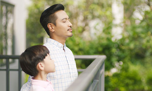 Dad and son standing outside enjoying the air.