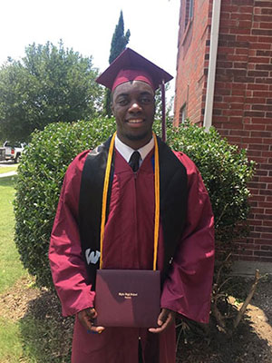 David in high school graduation cap and gown with diploma