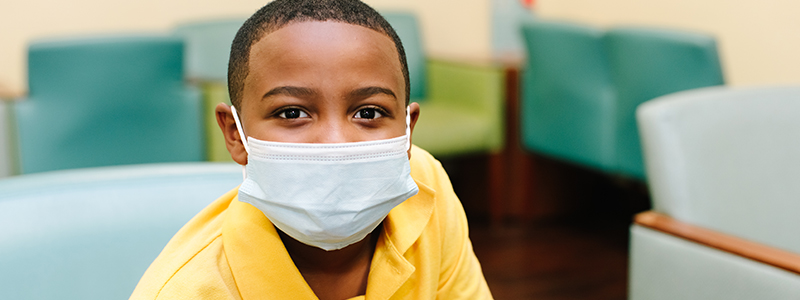 Bryson R. smiling through his mask - Children's Health