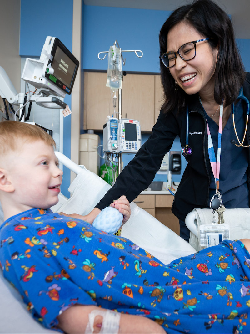 Gastroenterologist caring for and laughing with a pediatric patient