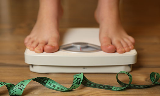Someone standing on a weight scale.