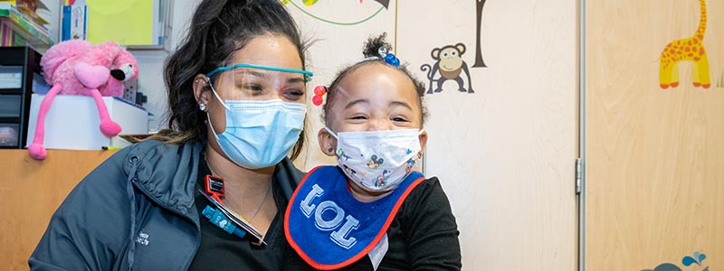 Reese, a child life assistant, and Shamiya share a big laugh between them in the playroom at Our Children's House.