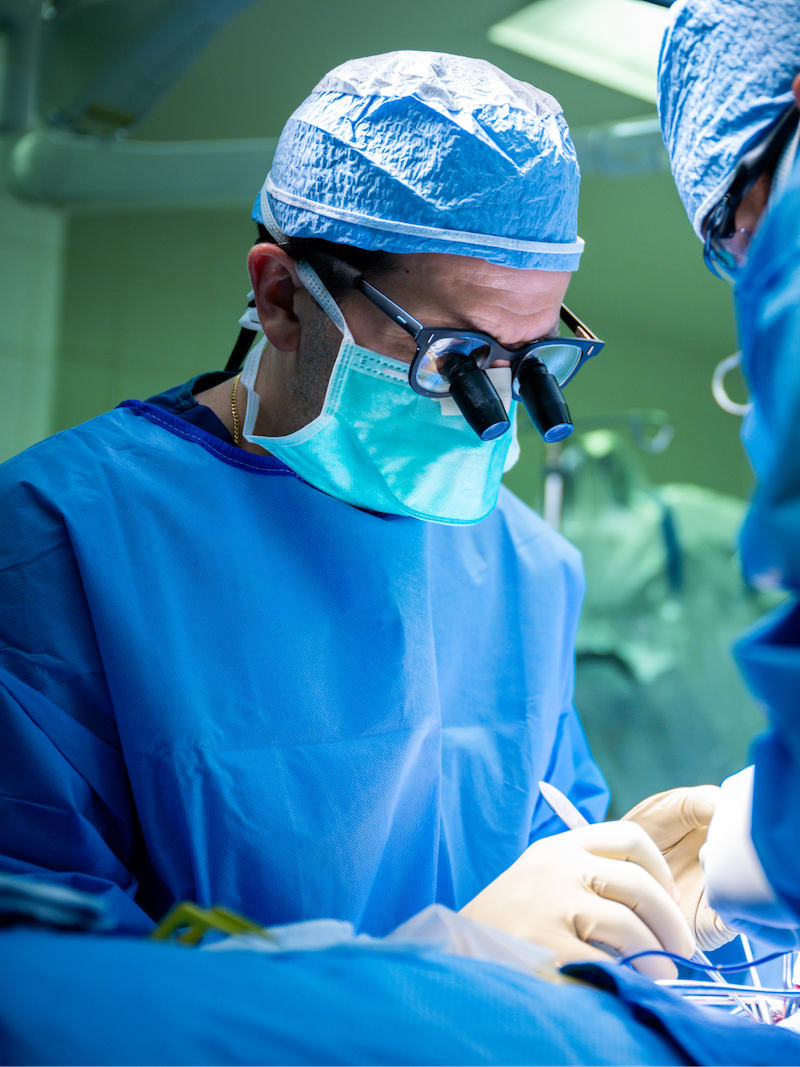 Neurologist performing surgery in scrubs