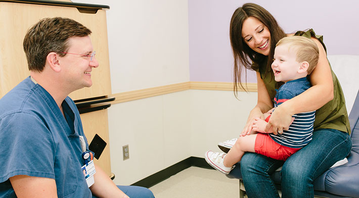 smiling doctor and toddler boy with mom